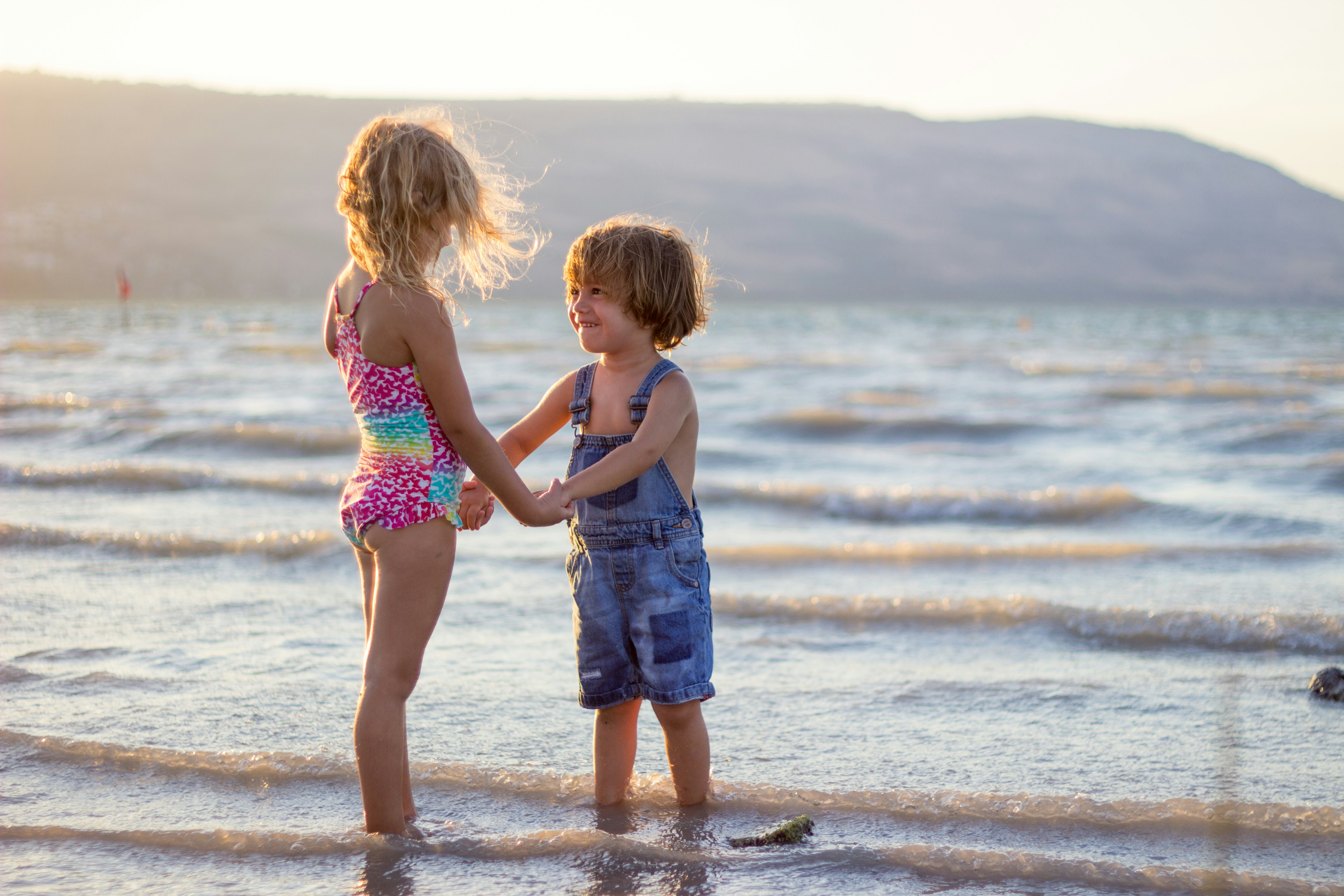 Two naked girls playing with one boy